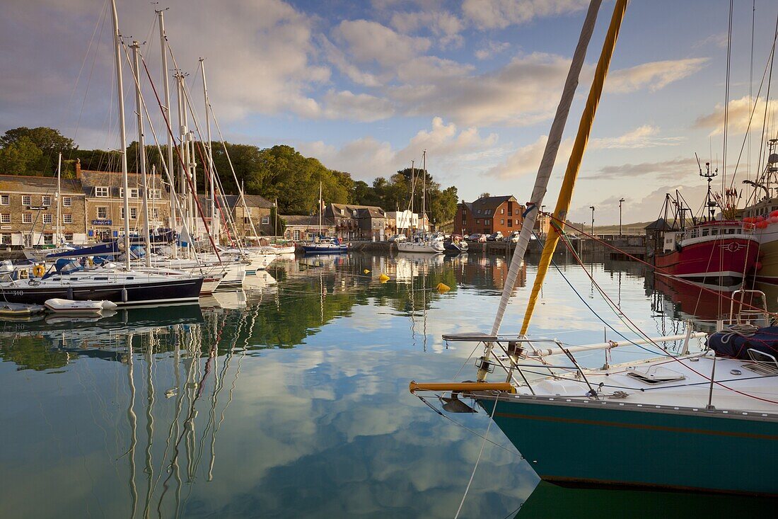 Low morning light and sailing yacht reflections at Padstow Harbour, Cornwall, England, United Kingdom, Europe