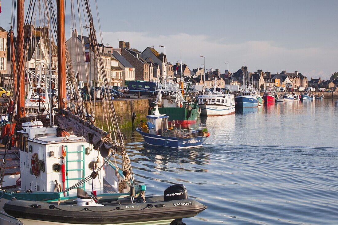 The Fleur de Lampaul, a protected historic monumen in the foreground, and small boat in the harbour at Saint Vaast La Hougue, Cotentin Peninsula, Normandy, France, Europe
