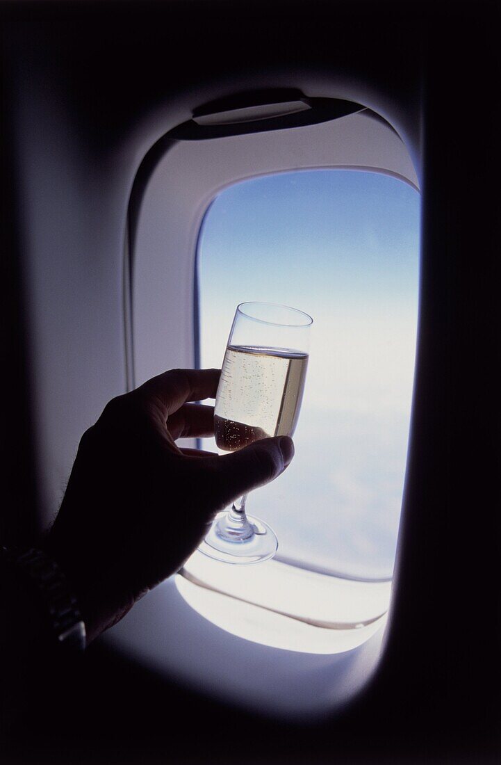 Glass of champagne at 30000 feet and aircraft window