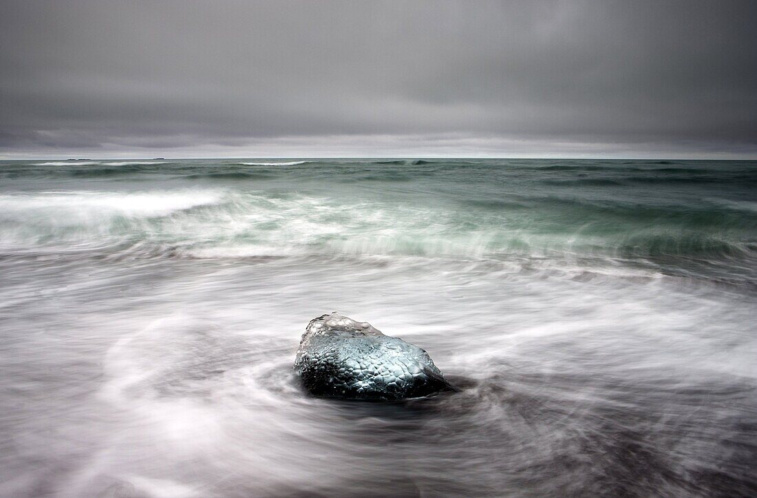 Piece of glacial ice washed ashore by the incoming tide near glacial lagoon at Jokulsarlon, Iceland, Polar Regions