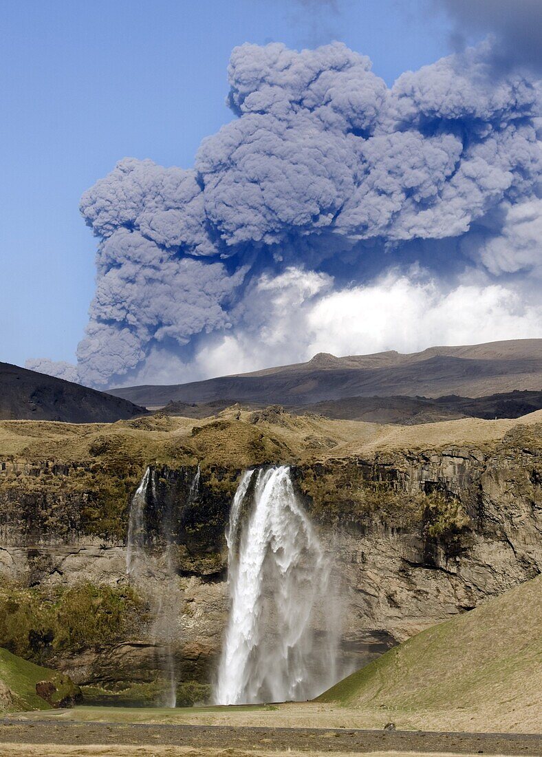 Distant view of the Seljalandsfoss waterfall with the ash plume of the Eyjafjallajokull eruption in the distance, near Hella, southern Iceland, Iceland, Polar Regions