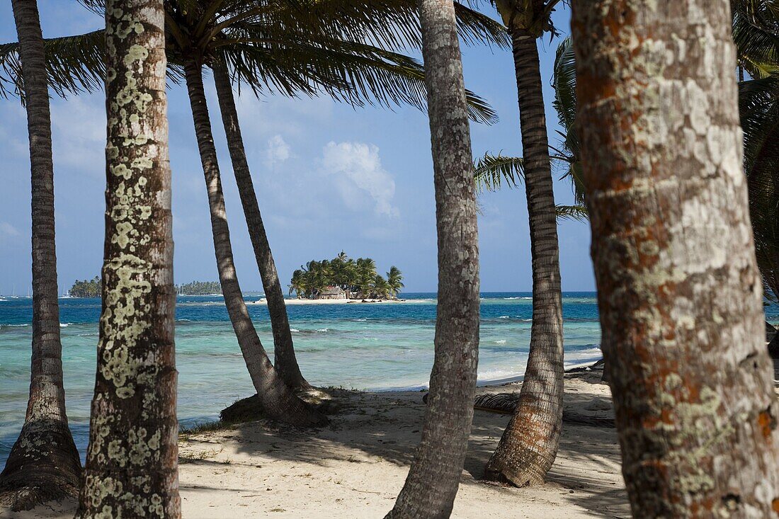 Islands in the San Blas archipelago in the Caribbean Sea, seen through palm trees on Dog Island, Panama, Central America