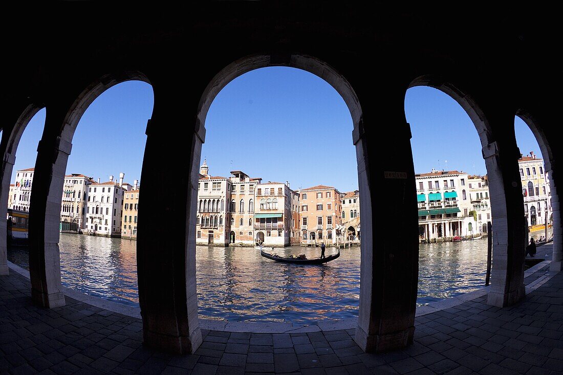 Gondola and gondolier taken through arches of the Rialto Market area, San Polo, Venice, UNESCO World Heritage Site, Veneto, Italy, Europe