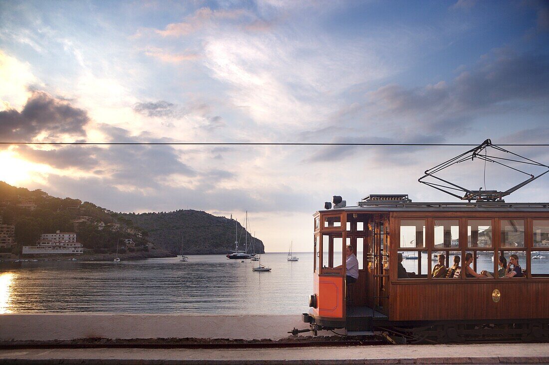 Tram at sunset set against yachts in bay, Soller, Mallorca, Balearic Islands, Spain, Mediterranean, Europe