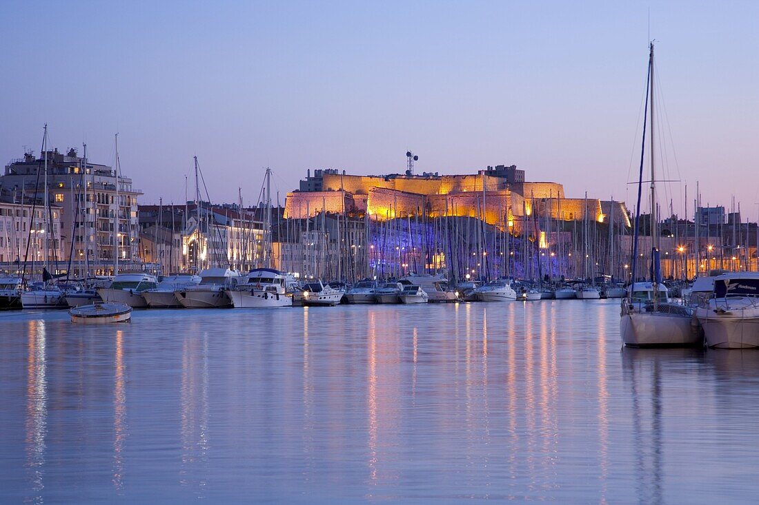 View across the Vieux Port to the illuminated Fort St.-Nicolas at dusk, Marseille, Bouches-du-Rhone, Cote d'Azur, Provence, France, Europe