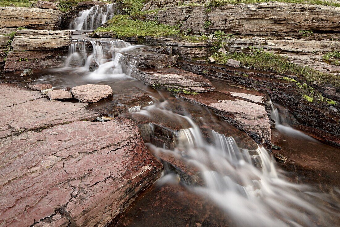 Cascades over red rock, Glacier National Park, Montana, United States of America, North America