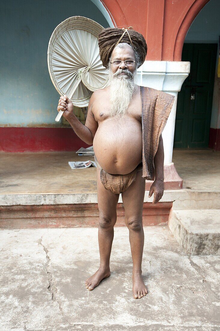 Joranda monk wearing tree bark loincloth, holding palm leaf fan, with uncut hair piled up on top of his head, Joranda, Orissa, India, Asia