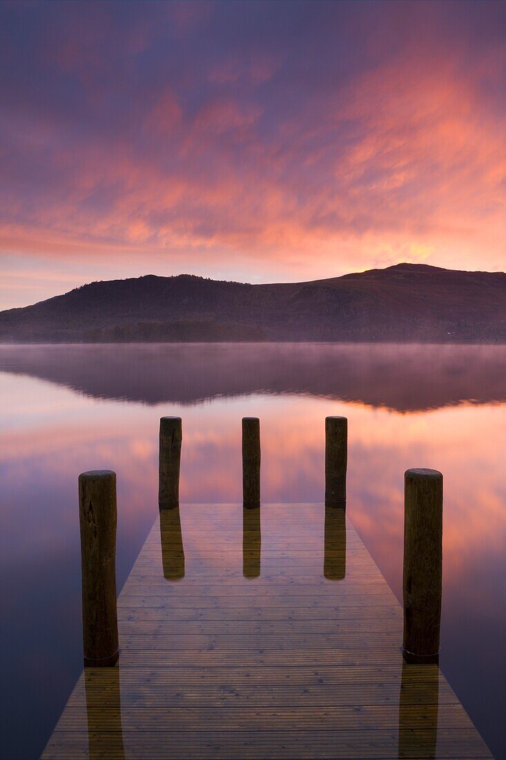 Fiery autumn sunrise over Derwent Water from Hawes End jetty, Lake District National Park, Cumbria, England, United Kingdom, Europe