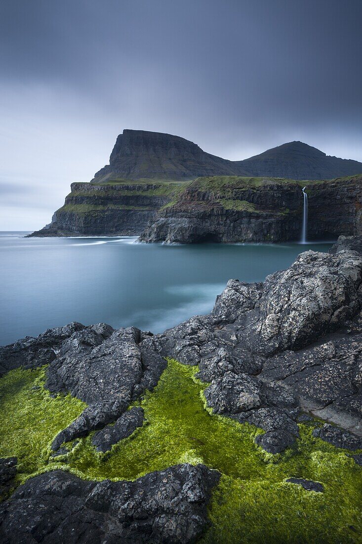 Dramatic coastline and waterfall at Gasadalur on the Island of Vagar, Faroe Islands, Denmark, Europe
