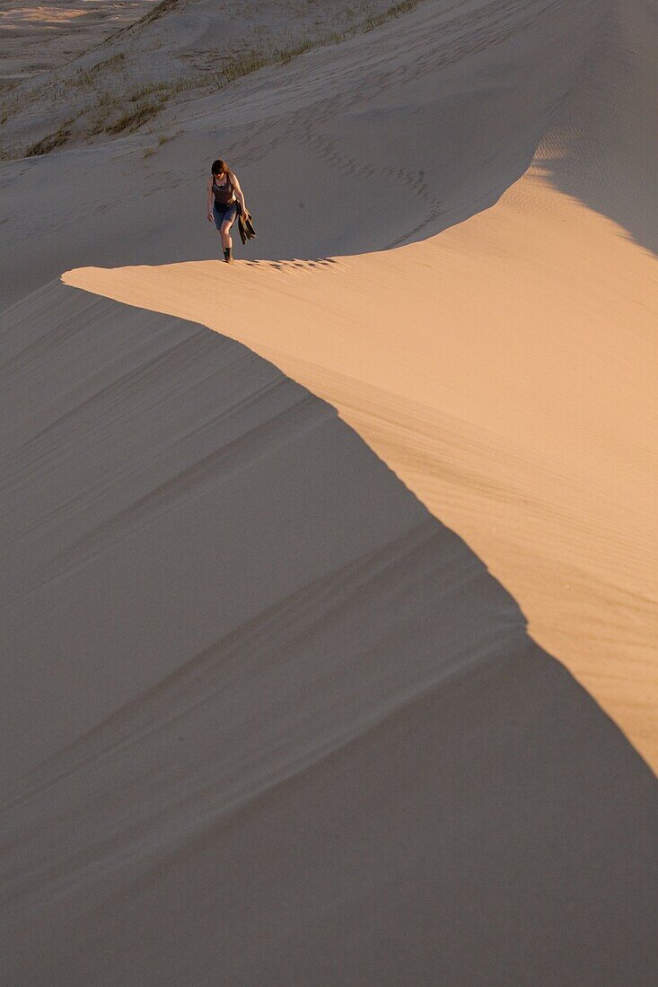 Woman walking through Kelso Dunes, Mojave Desert National Reserve, California, United States of America, North America