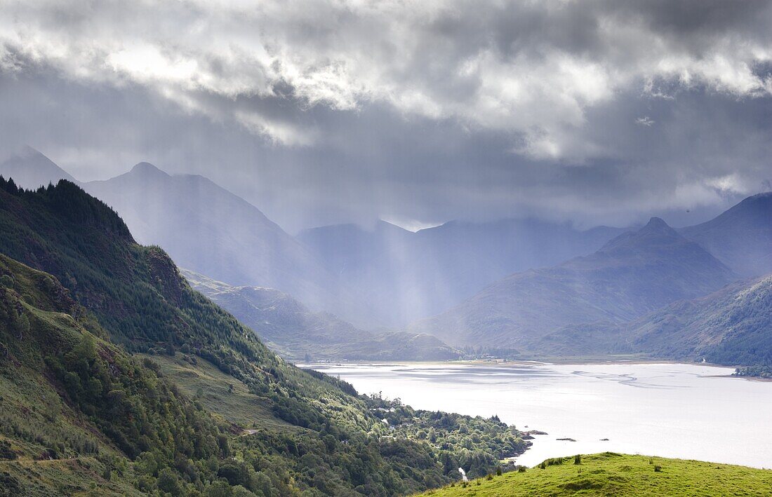 View from Carr Brae towards head of Loch Duich and Five Sisters of Kintail with sunlight bursting through sky, Highlands, Scotland, United Kingdom, Europe
