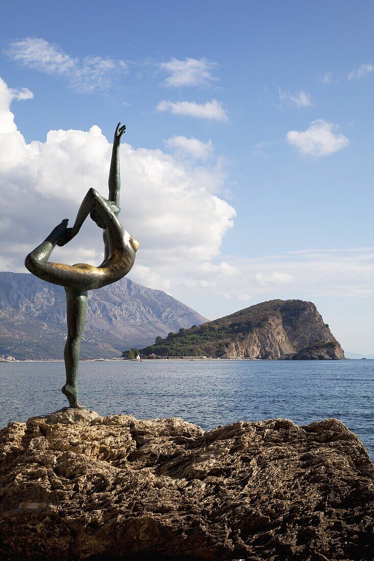 Statue of naked dancing girl on a rock near the Adriatic with Sveti Nikola island in the background, Budva, Montenegro, Europe