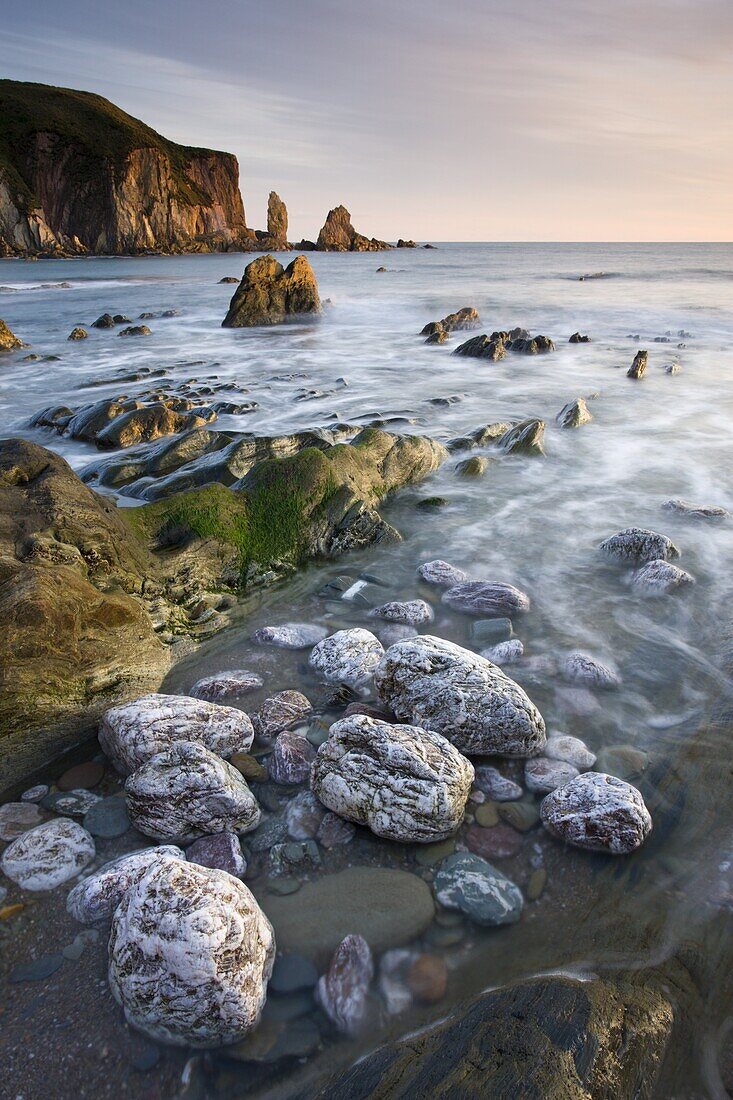 Golden evening sunlight catches the rocky coast of Bantham in South Devon, England, United Kingdom, Europe