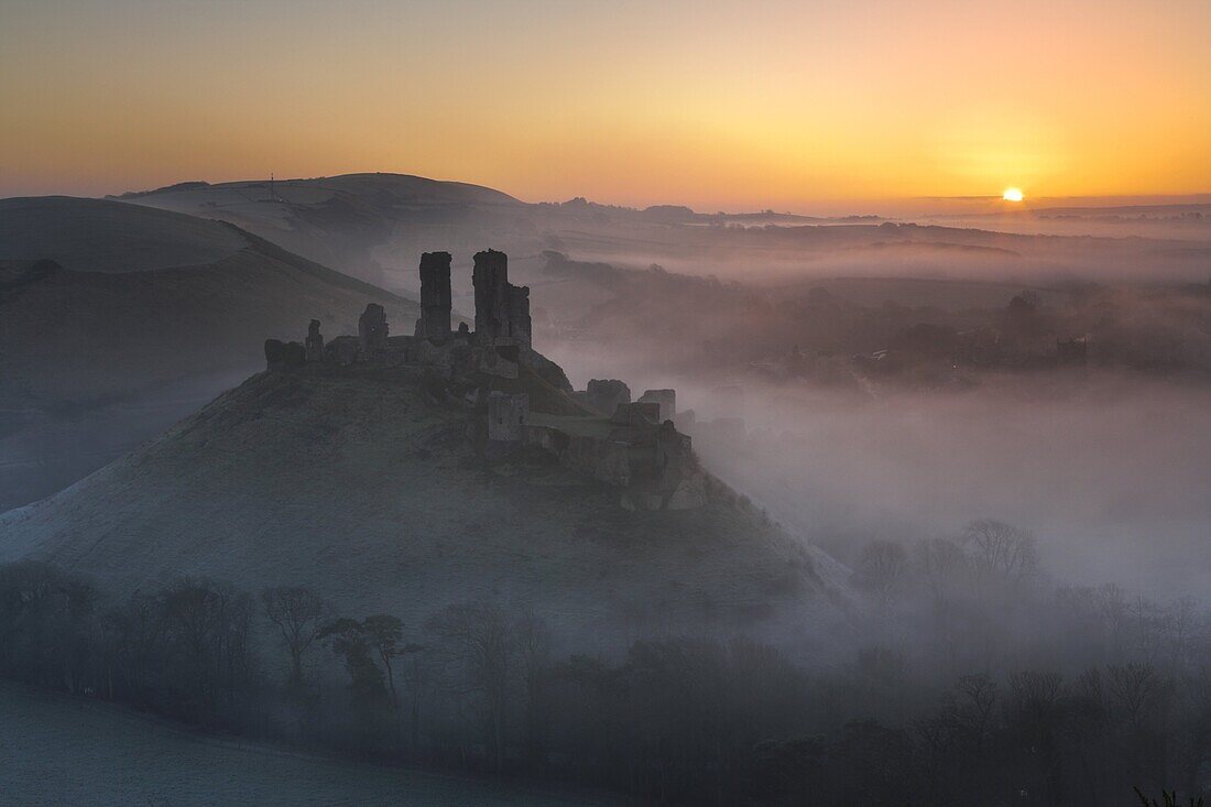 Mist surrounds the ruins of Corfe Castle at sunrise, Dorset, England, United Kingdom, Europe