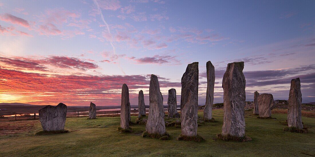 Fiery clouds above the standing stones of Callanish at sunrise in autumn, Island of Lewis, Outer Hebrides, Scotland, United Kingdom, Europe