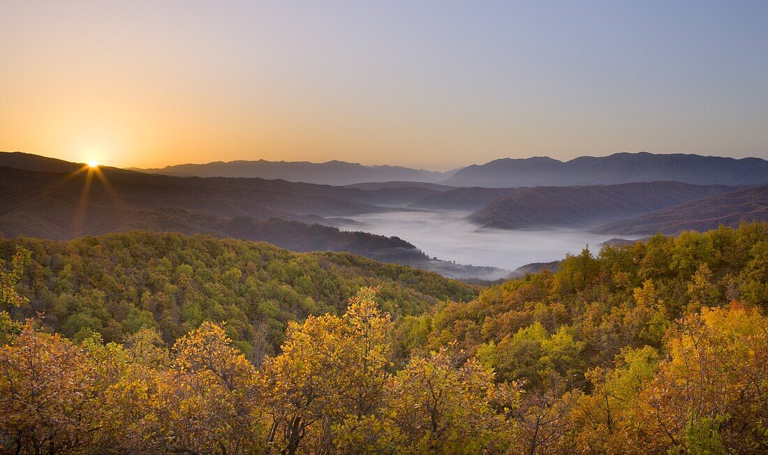 Autumn sunrise in Zagoria with the village of Kipi and a mist filled valley below, Epirus, Greece, Europe