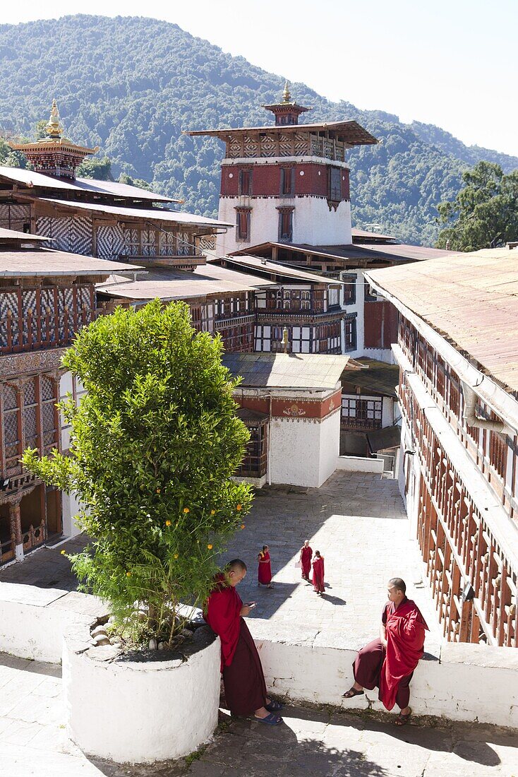 View over the main courtyard of Trongsa Dzong with Buddhish monks chatting, Trongsa, Bhutan, Asia