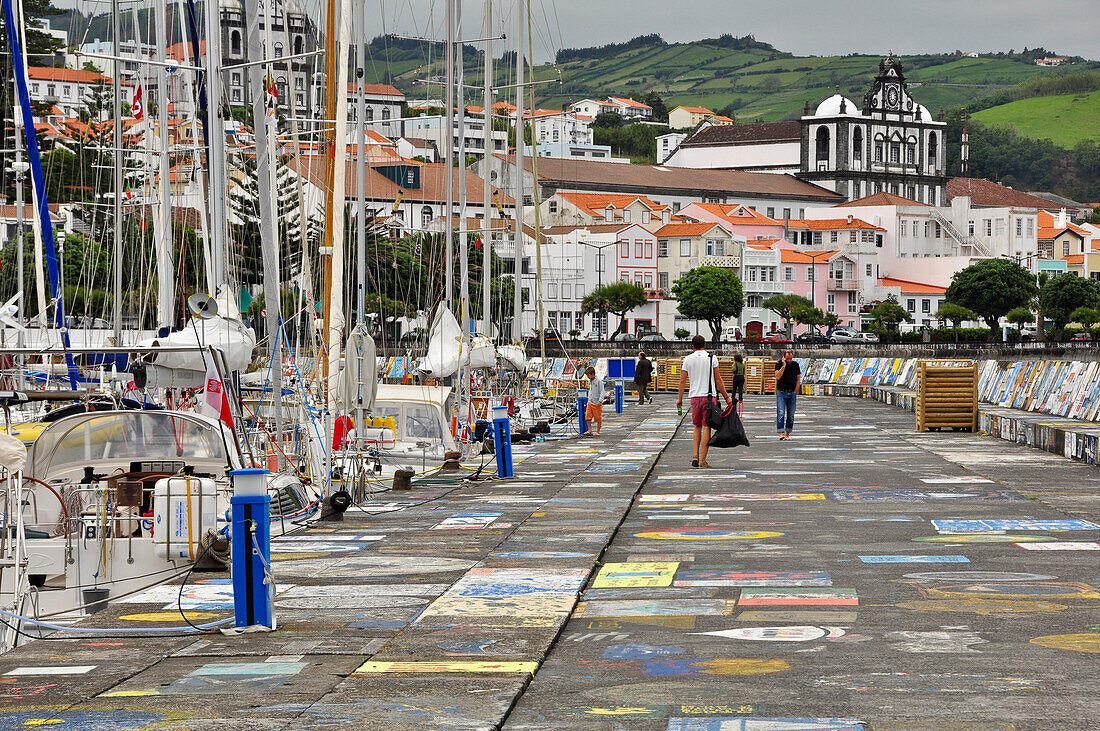 Harbour of city Horta with popular paintings on the harbour wall and sailing ships and sailors and the church Matriz de Sao Salvador, Marina da Horta, Island of Faial, Azores, Portugal, Europe, Atlantic Ocean