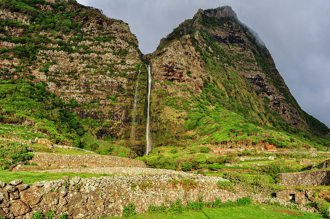 Waterfall Poco do Bacalhau, mountains and abandoned stone houses, Faja Grande, Island of Flores, Azores, Portugal, Europe, Atlantic Ocean