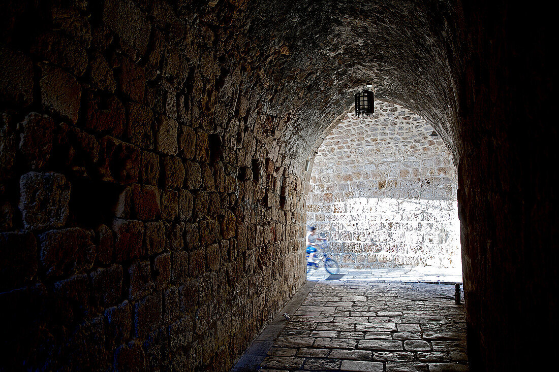 Little boy riding on his bike in the old town, Haifa, Israel