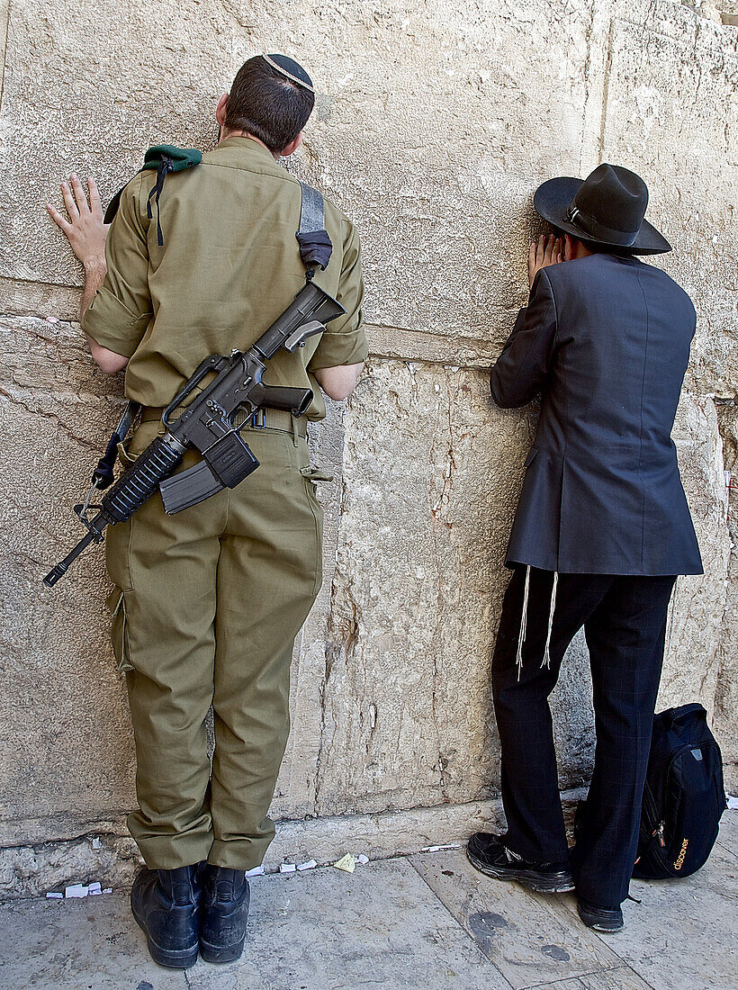 Soldier and man praying at the Western Wall, Jerusalem, Israel