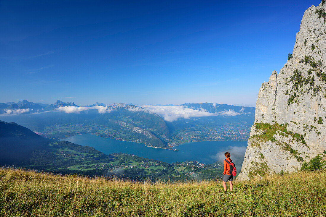 Woman hiking looking towards Lac d'Annecy, La Tournette, Haute-Savoie, France