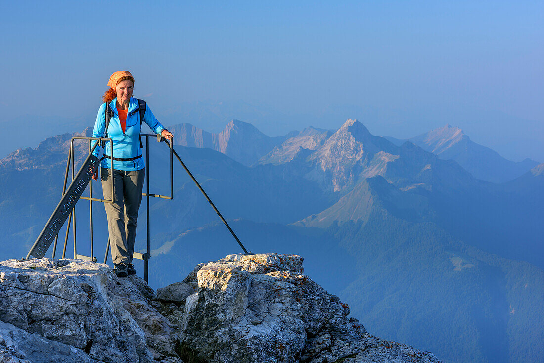 Frau beim Wandern steigt auf Leiter auf La Tournette, La Tournette, Hochsavoyen, Frankreich
