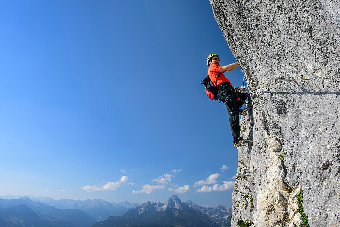 Man ascending fixed rope route, Watzmann in background, Hochthronklettersteig, fixed rope route Hochthron, Untersberg, Berchtesgadener Hochthron, Berchtesgaden Alps, Upper Bavaria, Bavaria, Germany