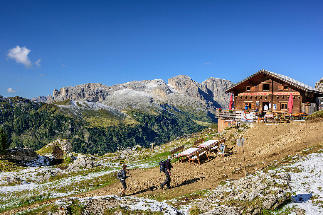 Wanderer gehen auf Rifugio Sandro Pertini zu, Rosengartengruppe im Hintergrund, Friedrich-August-Weg, Langkofelgruppe, Dolomiten, UNESCO Weltnaturerbe Dolomiten, Trentino, Italien