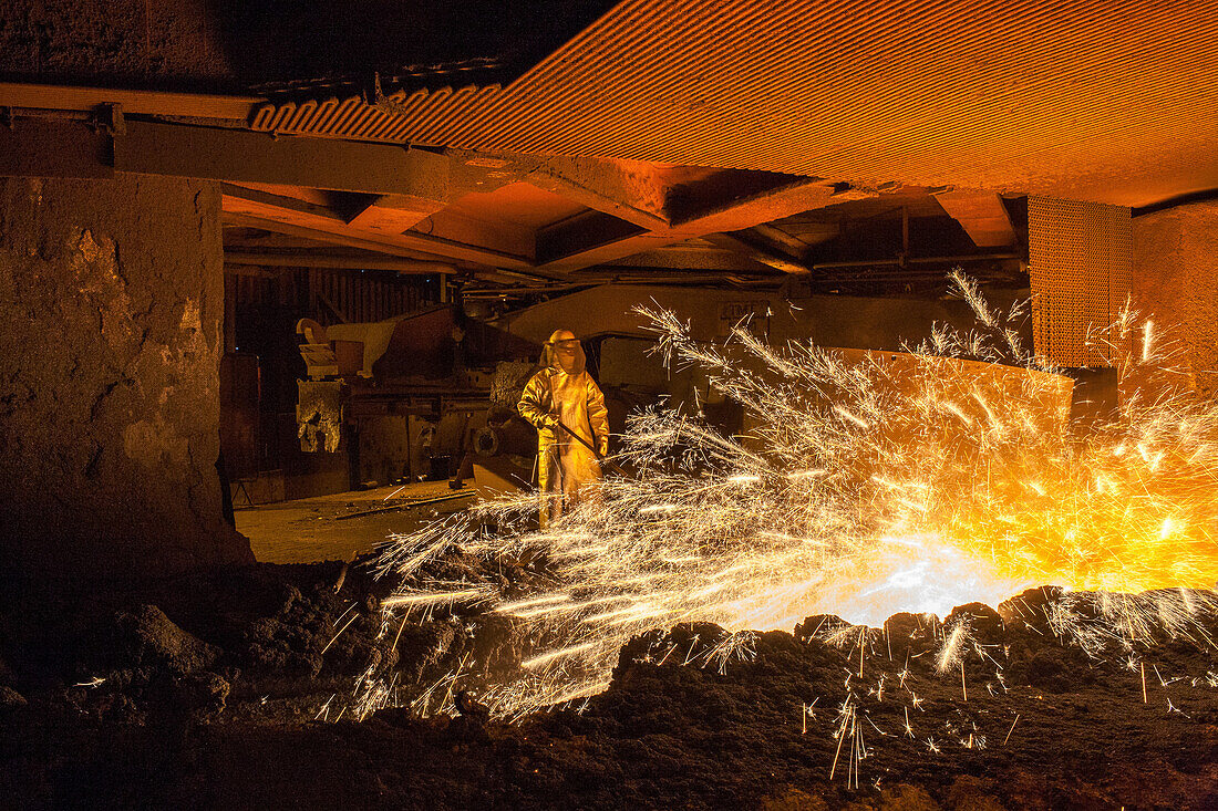 Salzgitter AG, Stahlwerk, Stahlhuette, Walzwerk, Hochofen, Stahlarbeiter in silbernem Schutzanzug, Funken, Glut, wie Lavastrom, Schlacke und Roheisen, Anstich, Industrie, Niedersachsen, Deutschland