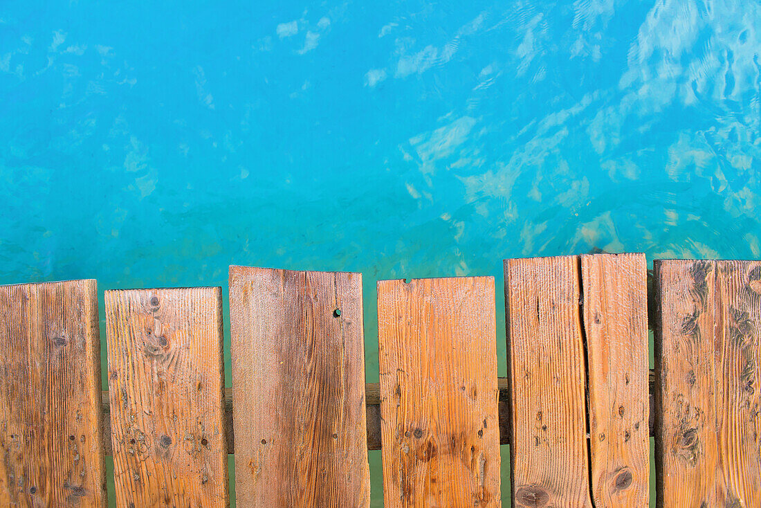 Detailaufnahme aus der Draufsicht eines Holzsteg mit türkis Wasser. Strand Playa de Muro, Alcudia, Mallorca, Balearen, Spanien