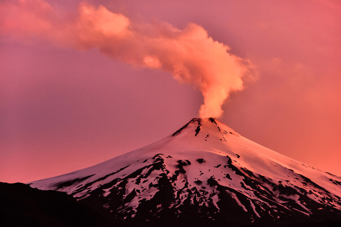 'Vulkan Villarrica bei Sonnenuntergang, schneebedeckt, Rauchsäule kündigt Vulkansausbruch und Eruption an, Stratovulkan, Nationalpark Villarrica, Pucon, Región de la Auracania, Region Los Rios,  Patagonien, Anden, Chile, Südamerika, Amerika;'