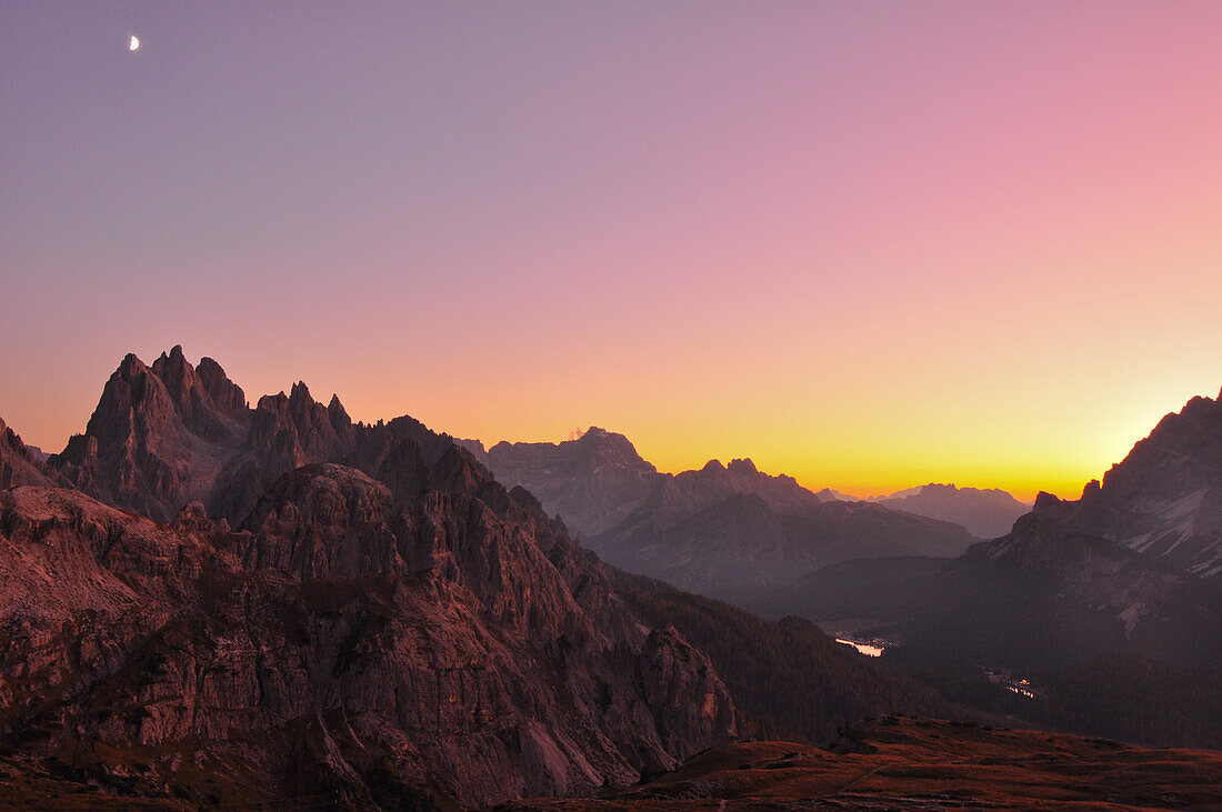 Bergketten und Cadini Gruppe (Cadini di Misurina) mit Blick auf Misurina und See Lago Misurian nach Sonnenuntergang mit Mond, Hochpustertal, Sexten, Sextener Dolomiten, Südtirol, Trentino, Belluno, Venetien, Alto Adige, Drei Zinnen (Tre Cime di Lavaredo) 