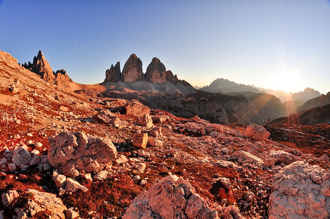 Sunset and sun rays over Paternkofel and Three Peaks (Drei Zinnen), scree and boulder field, Val Pusteria Valley, Sesto, Dolomites, South Tyrol, Veneto, Alto Adige, Three Peaks (Tre Cime di Lavaredo) Nature Park, UNESCO world heritage side, Italy, Europea