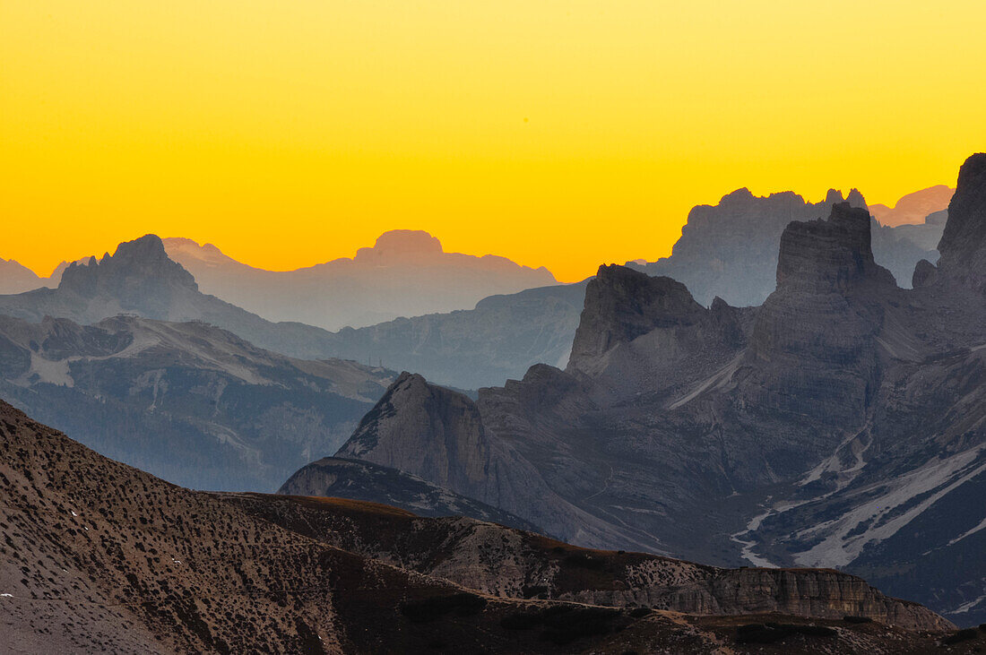 Leuchtende Berge und Sonnenuntergang über Bergketten von den Drei Zinnen aus, Hochpustertal, Sexten, Sextener Dolomiten, Südtirol, Trentino, Belluno, Venetien, Alto Adige, Drei Zinnen (Tre Cime di Lavaredo) Naturpark, UNESCO Welterbe, Italien, Alpen, Euro