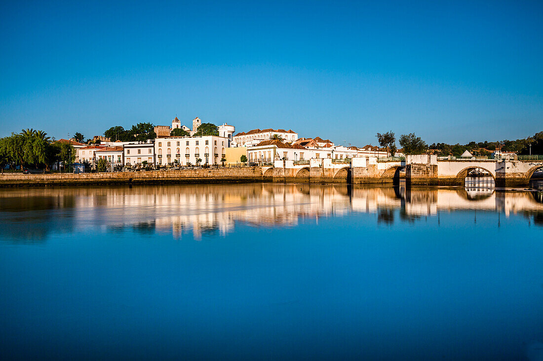 Blick über Rio Gilao auf die Stadt mit römischer Brücke, Tavira, Algarve, Portugal