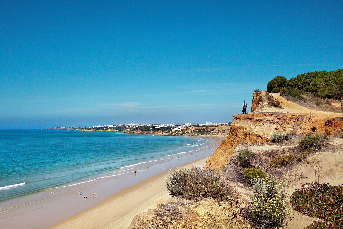 Hiker on cliffs, Praia de Falesia, Albufeira, Algarve, Portugal