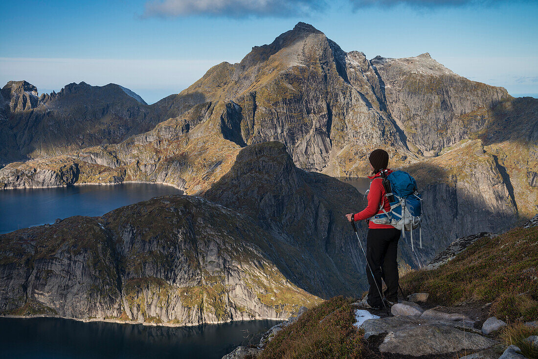 Female hiker takes in view of mountains from trail to Munken, Moskenesøy, Lofoten Islands, Norway