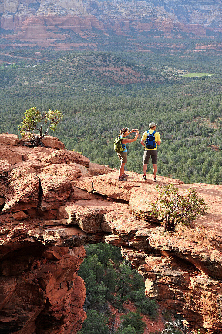 Hikers on the Devil's Bridge in Red Rock-Secret Mountain Wilderness Area outside Sedona, Arizona May 2011.  The Devil's Bridge is an easy two-mile hike with spectacular views.