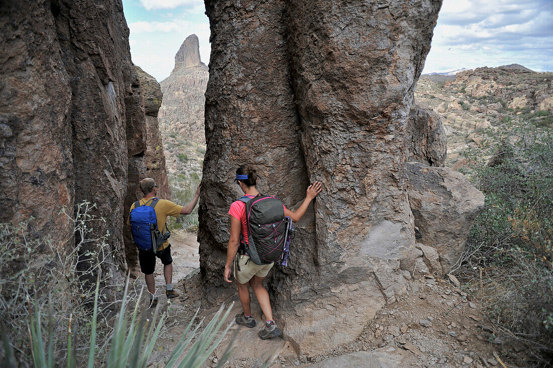 Man and woman backpackers explore the rock formations at Fremont Saddle on the popular Peralta Trail in the Superstition Wilderness Area, Tonto National Forest near Phoenix, Arizona November 2011.  The trail offers spectacular views of Weavers Needle and 