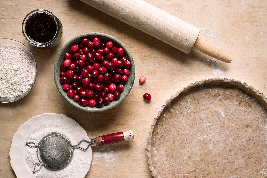 Ingredients for a cranberry tart with an almond and spelt flour crust, maple syrup and powdered sugar.