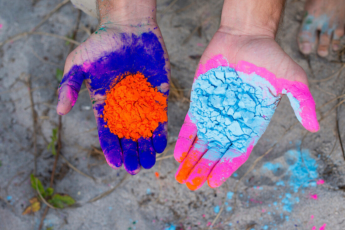 Caucasian man holding colorful paint powder