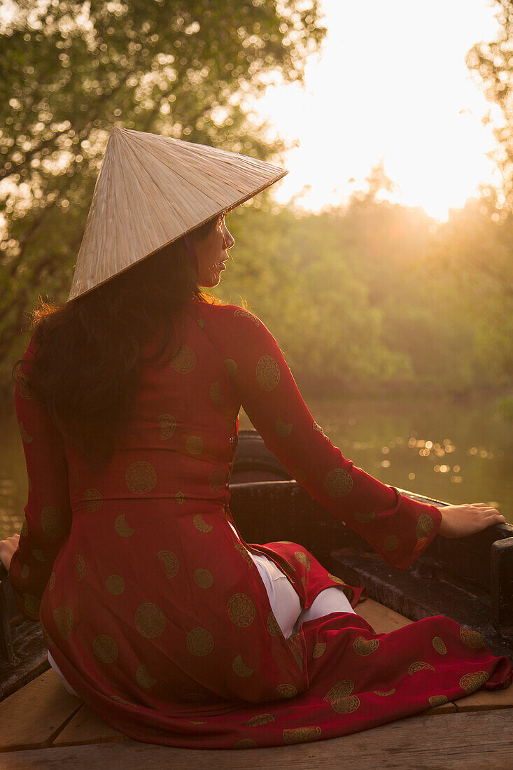 Woman wearing ao dai dress in boat, Can Tho, Mekong Delta, Vietnam, Indochina, Southeast Asia, Asia