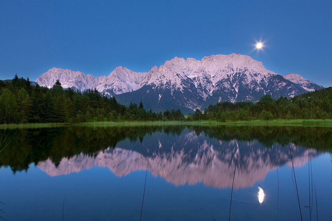 Full moon reflecting at Luttensee, view to Karwendel, near Mittenwald, Werdenfels region, Bavaria, Germany