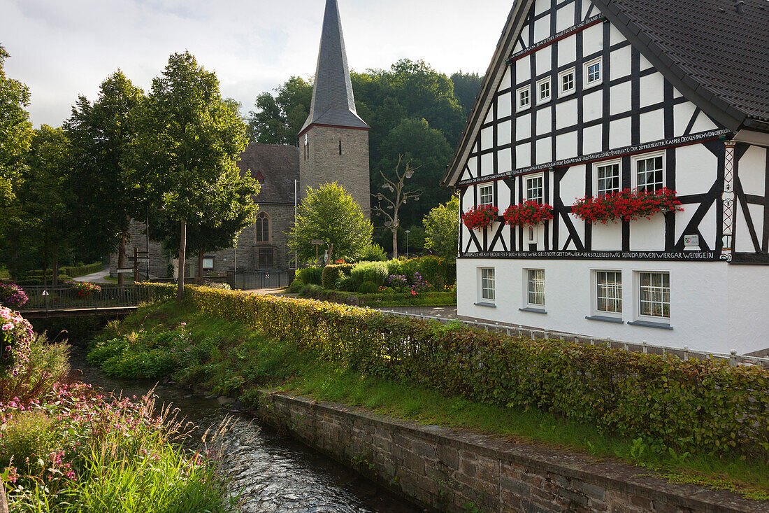Half-timbered house and church in the village Kirchveischede, near Lennestadt, Rothaargebirge, Sauerland region, North Rhine-Westphalia, Germany
