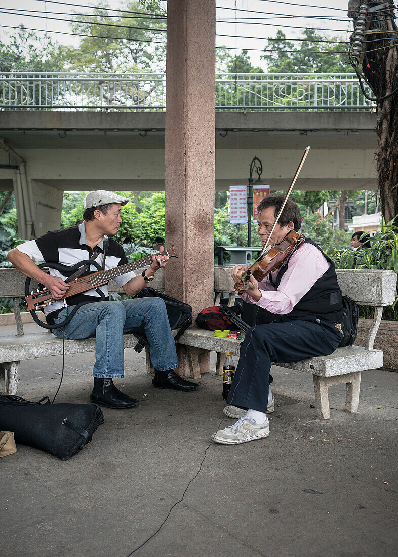 chinesische Jam Session mit Gitarre und Geige im Park, Guangzhou, Guangdong Provinz, Perlfluss Delta, China