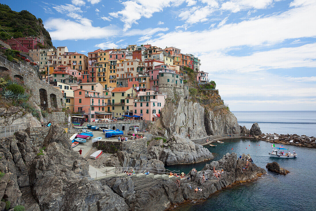 A view of Manarola with clear blue ocean and colourful buildings, Manarola, Liguria, Italy