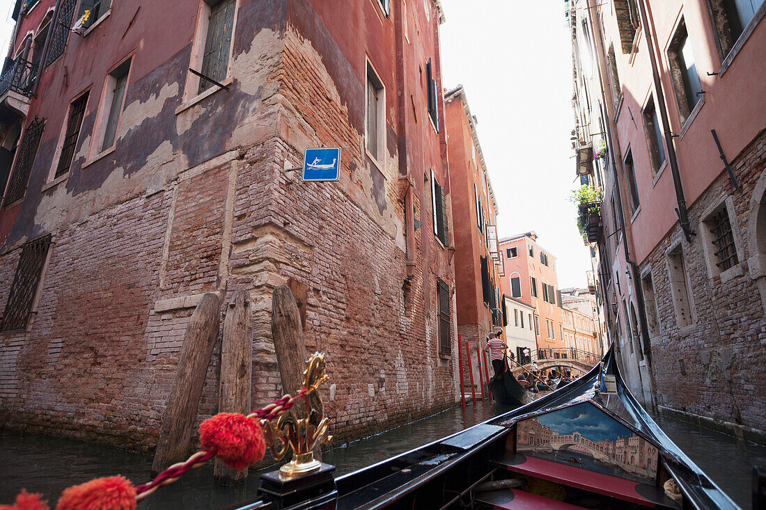 View of buildings along a narrow canal from a gondola, Venice, Italy