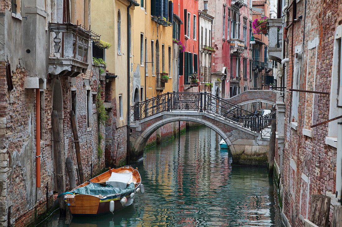 A small canal with a boat and bridge, Venice, Italy