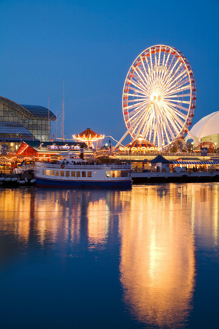 Chicago, Illinois Boat Leaving Navy Pier At Night, Ferris Wheel, Lights Reflected In Water Of Lake Michigan